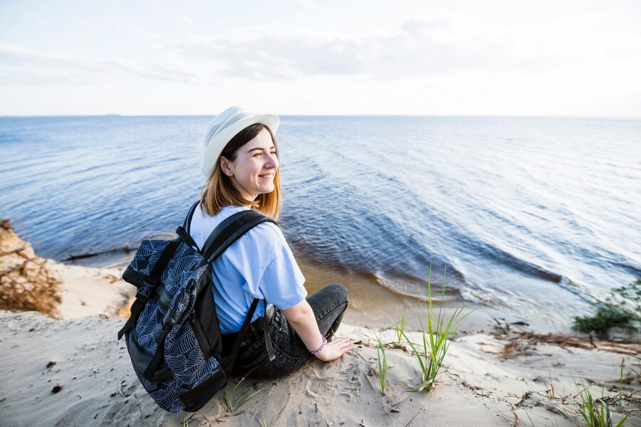 smiling woman sitting near sea
