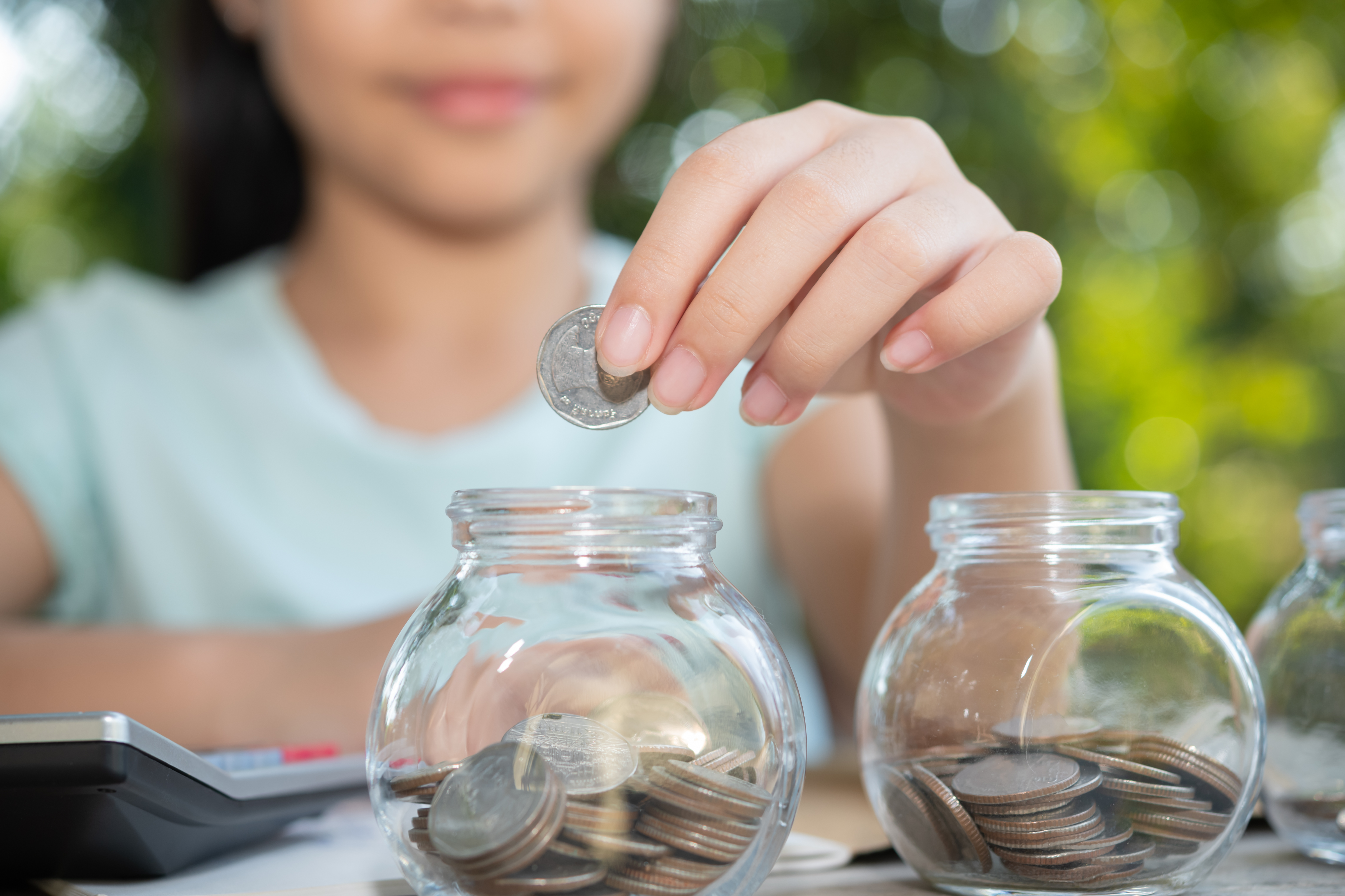 cute-asian-little-girl-playing-with-coins-making-stacks-money-kid-saving-money-into-piggy-bank-into-glass-jar-child-counting-his-saved-coins-children-learning-about-future-concept