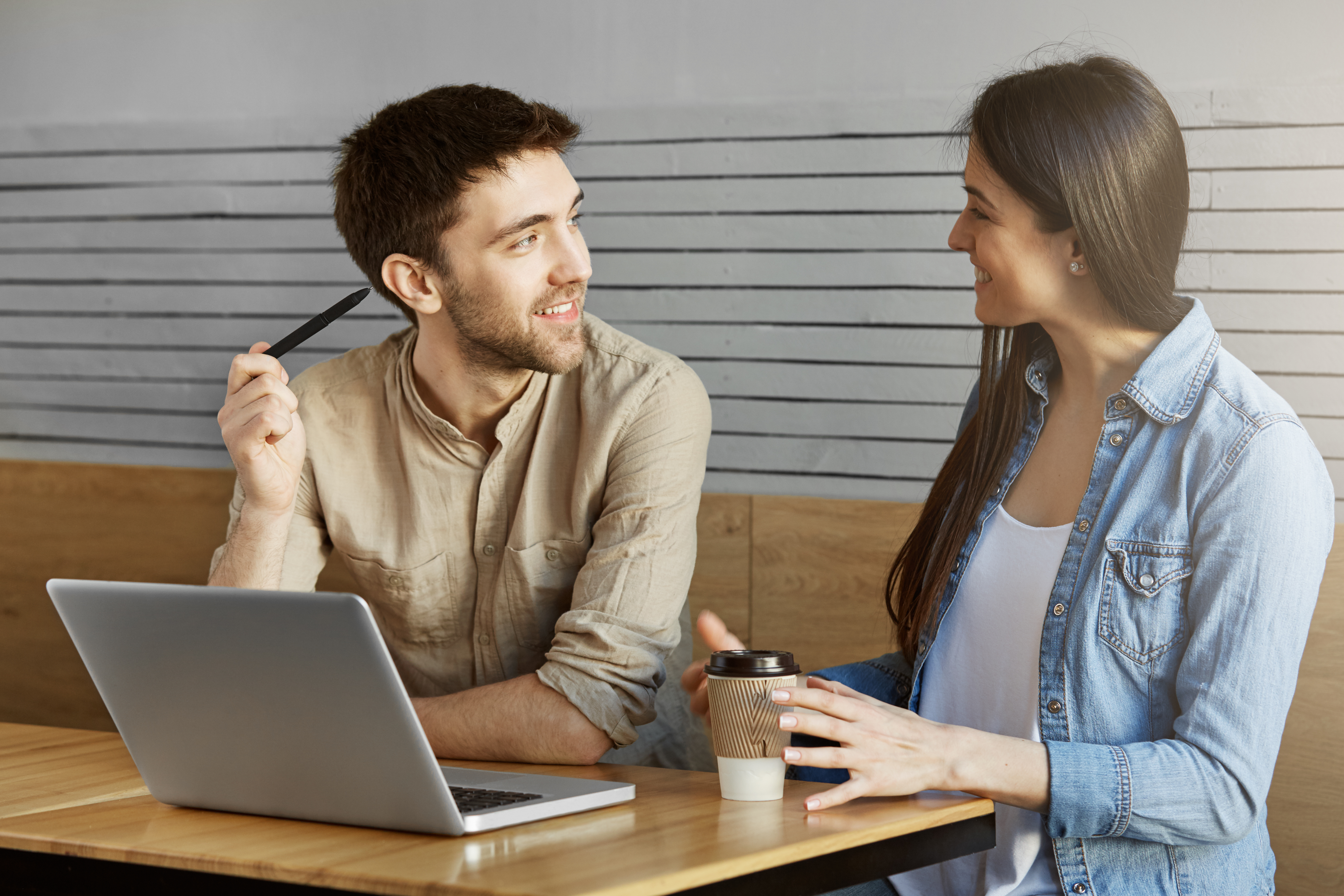handsome-unshaven-male-freelancer-sitting-meet-cafe-showing-project-customer-talking-about-work-details