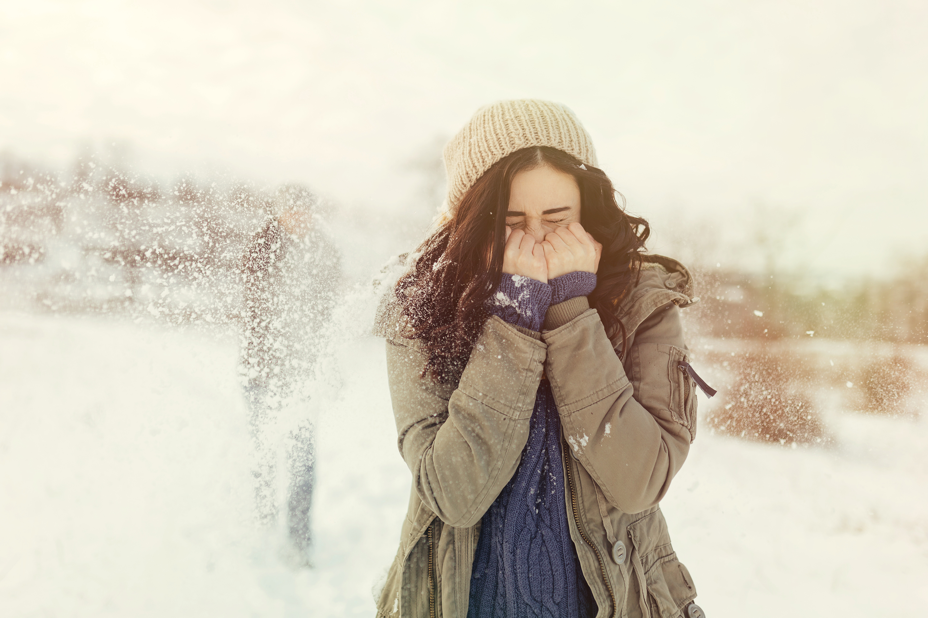 cheerful-young-couple-playing-snowballs