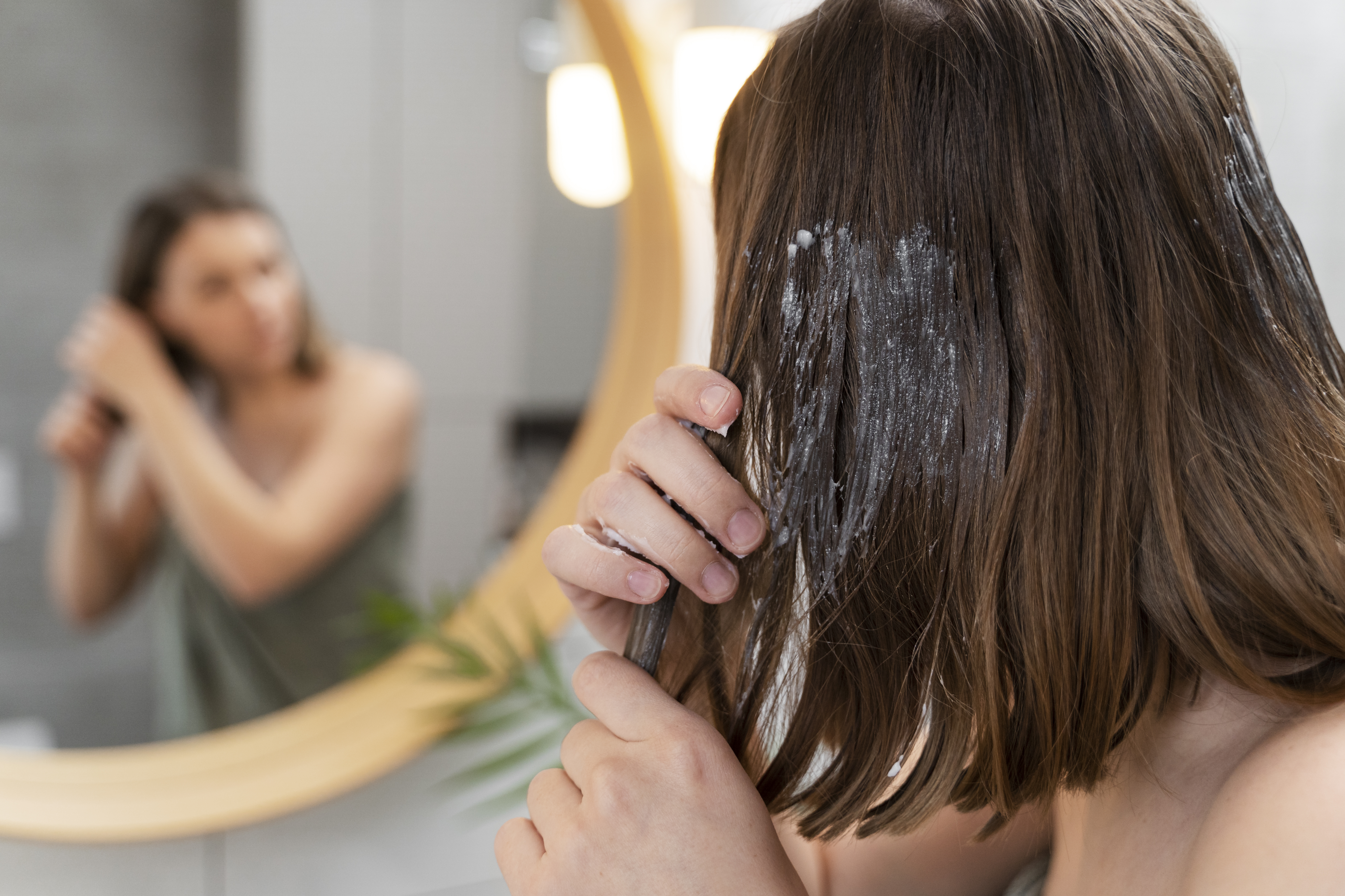 young-woman-applying-anti-dandruff-product
