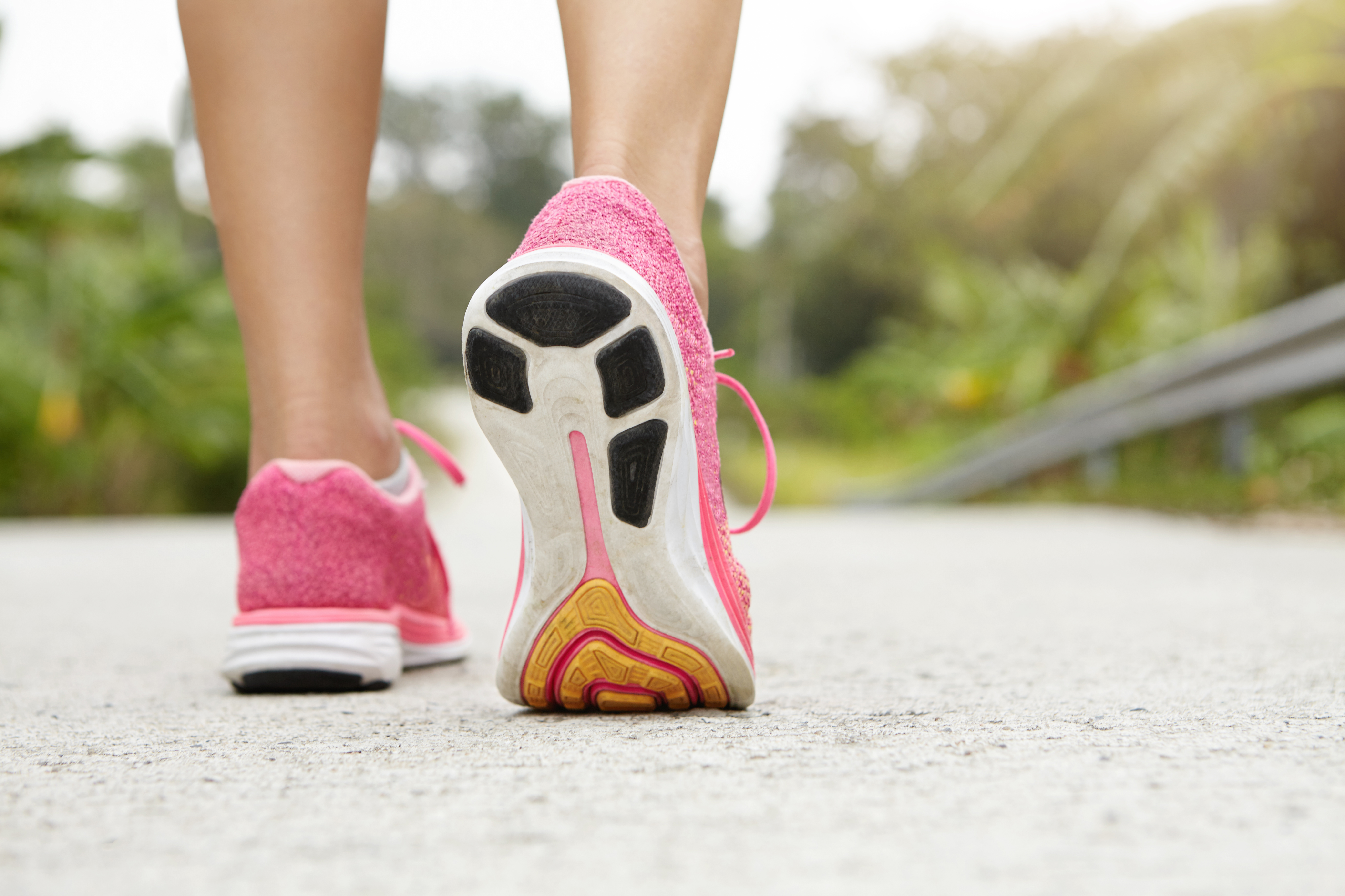 cropped-rear-shot-athletic-girl-wearing-pink-sneakers-while-hiking-jogging-pavement-outdoors-woman-jogger-with-fit-beautiful-legs-doing-workout