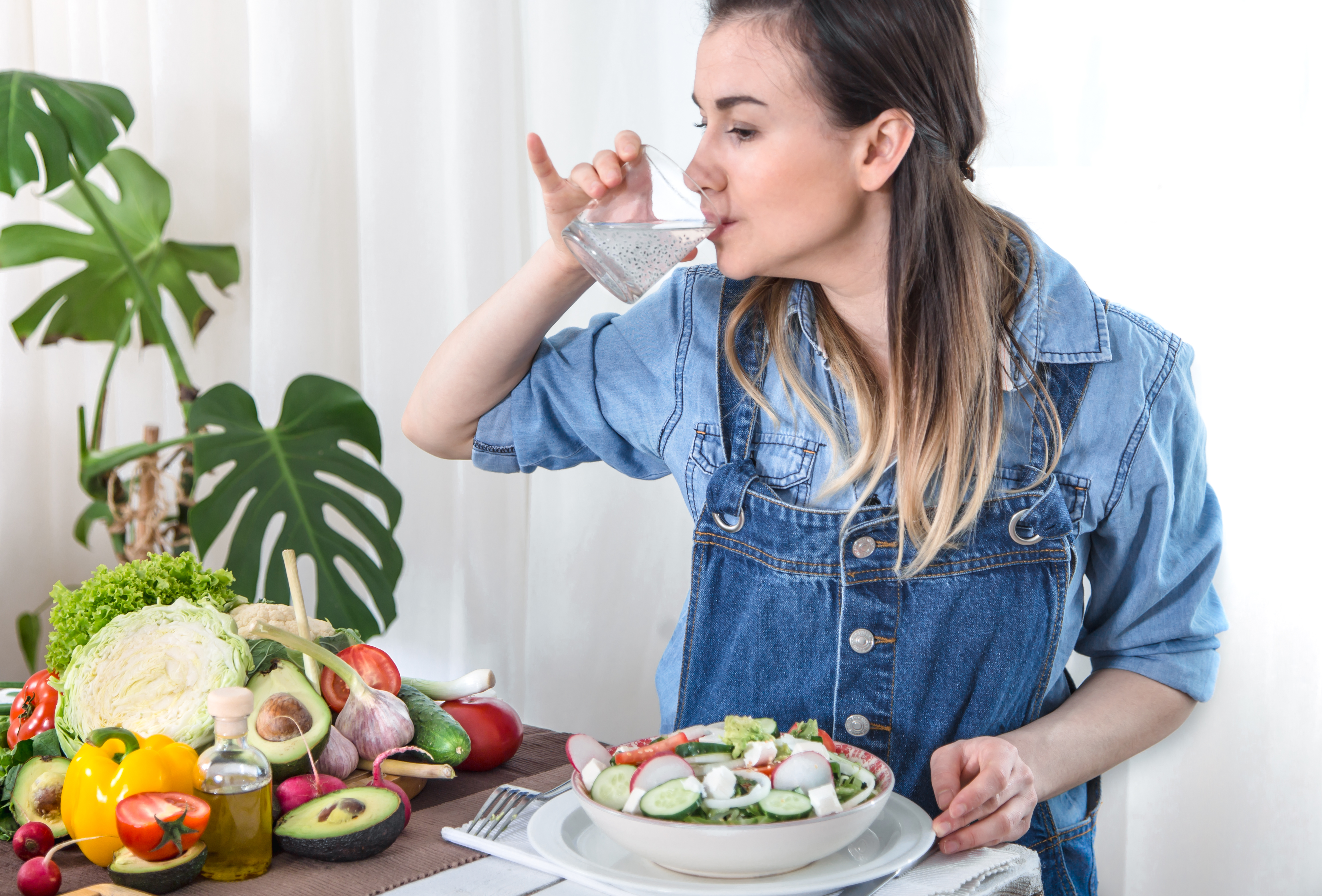 young-woman-drinking-water-table-with-vegetables