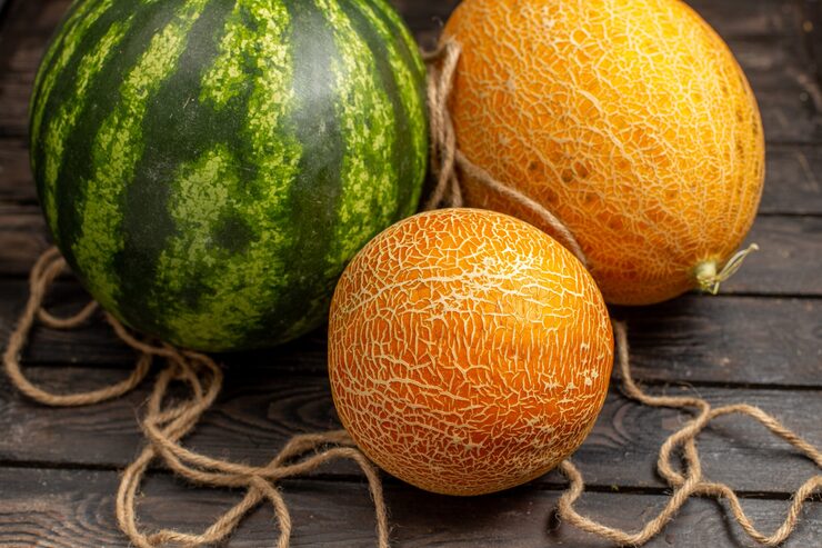 front-close-view-green-watermelon-whole-round-formed-fresh-juicy-fruit-with-melons-brown-rustic-desk-fruit-juice-fresh_140725-26697