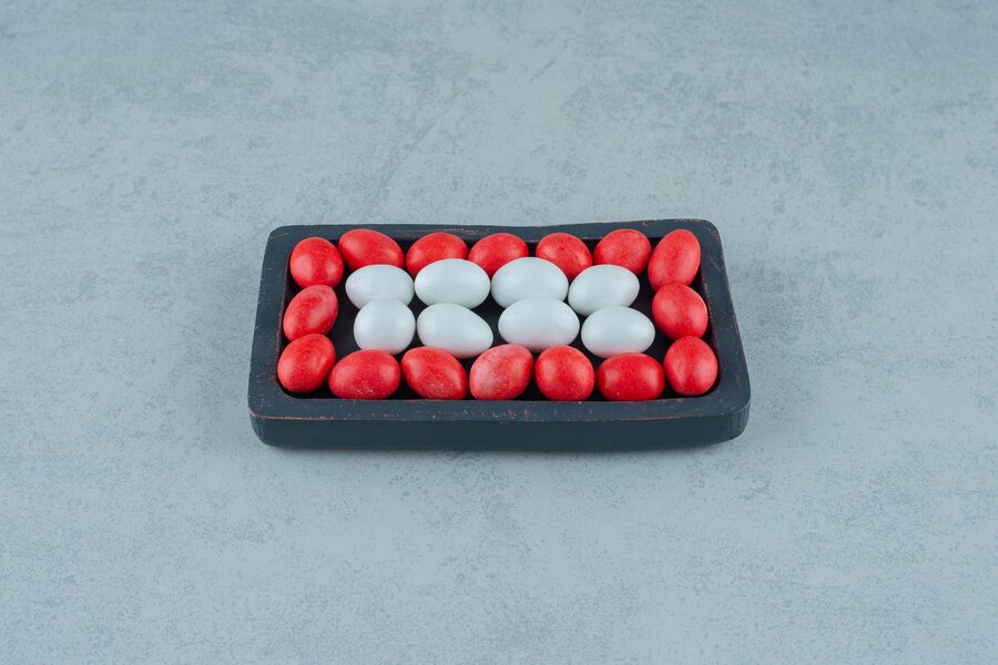 dark-wooden-board-full-round-sweet-colorful-candies-white-surface_114579-67151