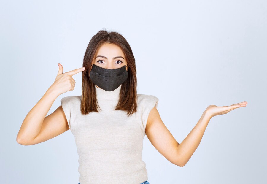 young-woman-with-black-medical-mask-pointing-her-head_144627-62674