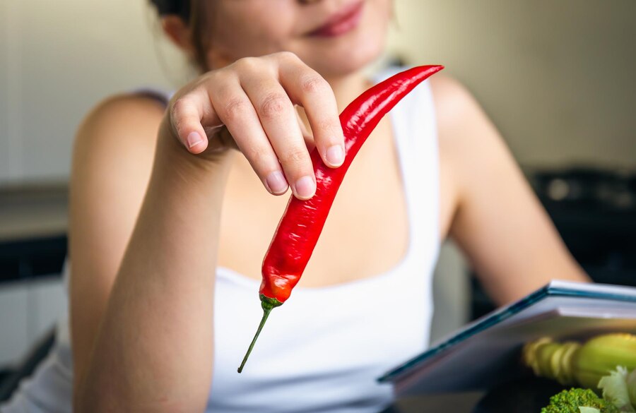 chili-pepper-female-hands-kitchen-blurred-background_169016-24564