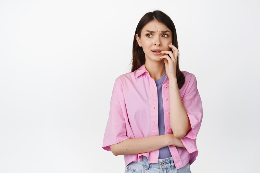 anxious-girl-bites-finger-looking-scared-worried-aside-overthinking-standing-white-background_176420-47985