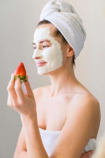 side-view-woman-with-face-mask-holding-strawberry_23-2148520257