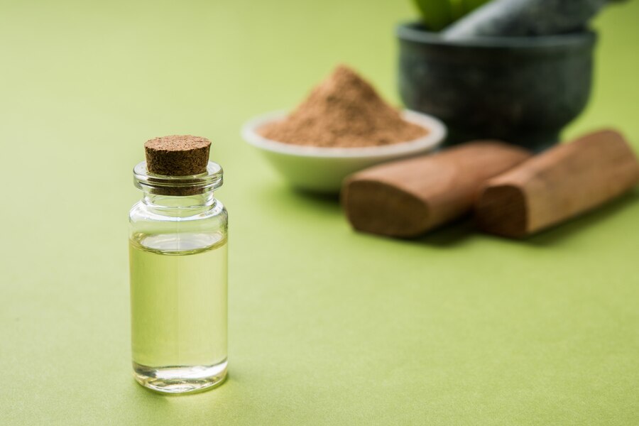 chandan-sandalwood-powder-with-sticks-traditional-mortar-perfume-oil-miniature-bottle-green-leaves-selective-focus_466689-15025
