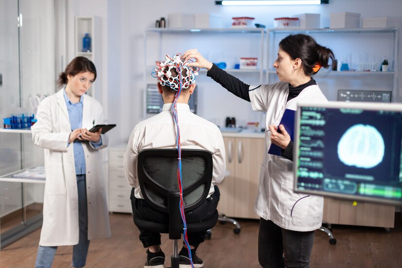 back-view-man-patient-wearing-performant-brainwave-scanning-headset-sitting-neurological-research-laboratory-while-medical-researcher-adjusting-it-examining-nervous-system-typing-tablet_482257-16484