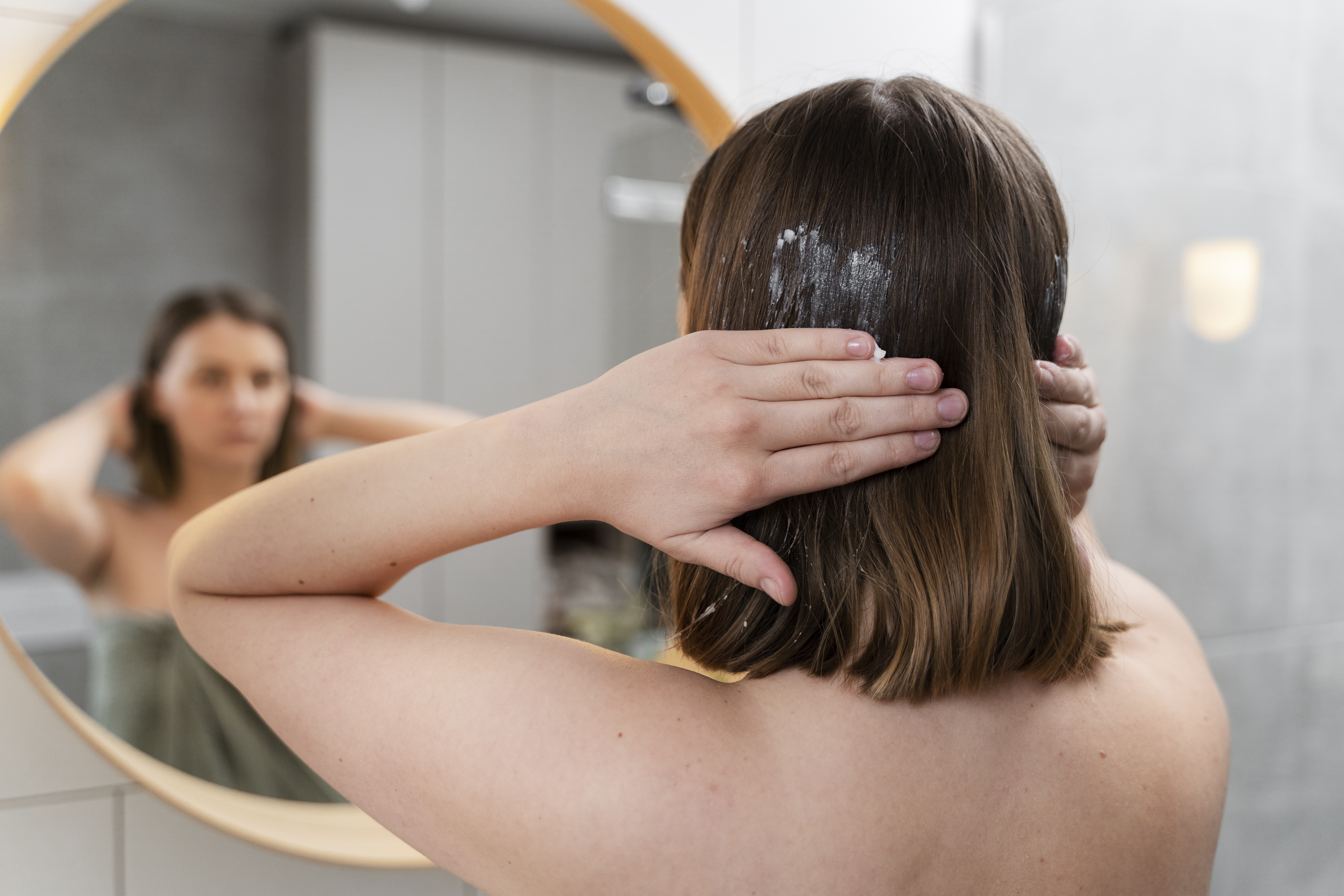 young-woman-applying-anti-dandruff-product