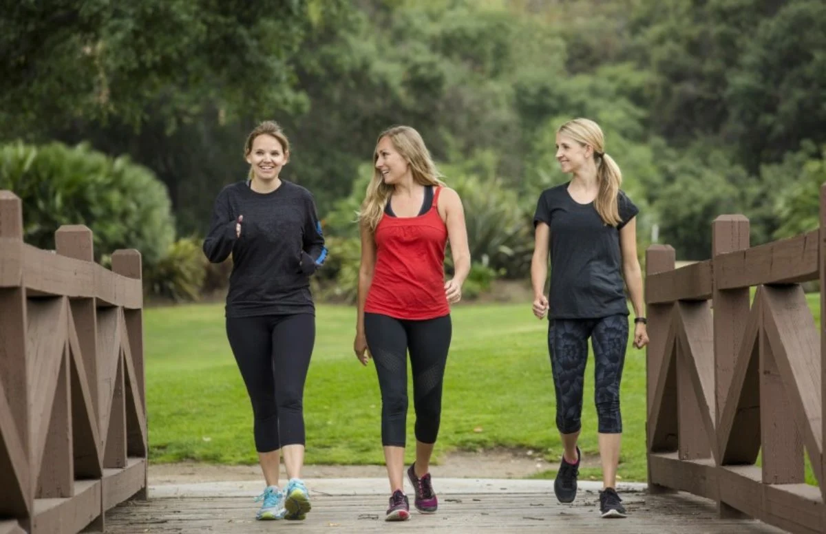 Three-women-walking-across-bridge-1200x776