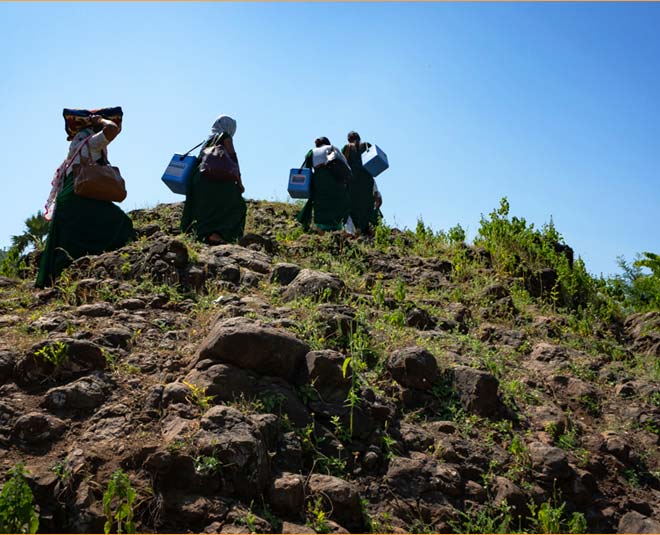 healthcare workers trekking uphill
