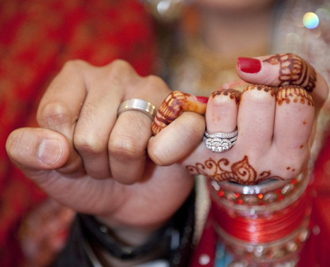 man and woman holding ring finger hands