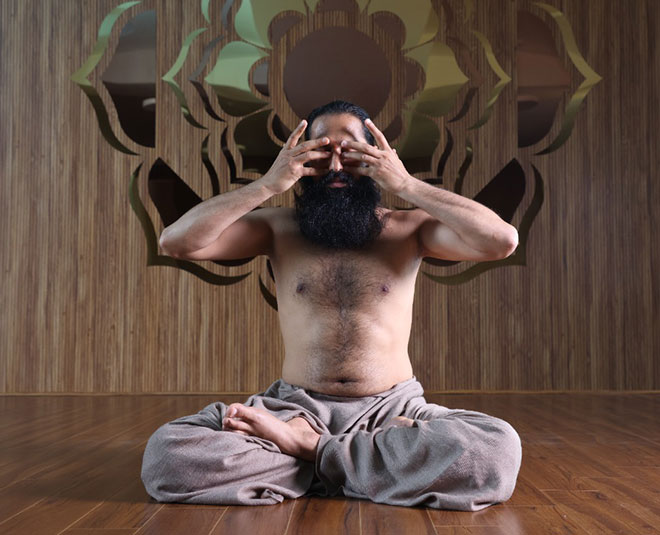 From above side view of relaxed flexible female sitting in Lotus pose and  meditating with closed eyes on mat on meadow at sundown stock photo - OFFSET