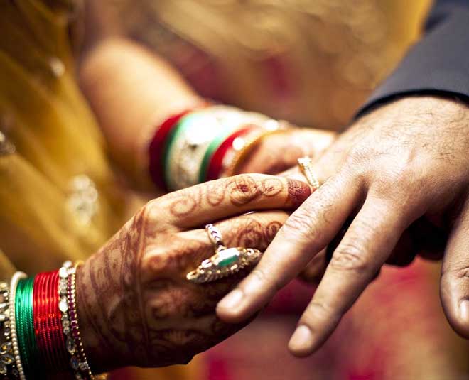 The wedding rings on the hands of an Indian bride and groom Stock Photo -  Alamy