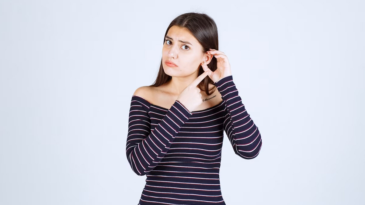 девушка показывает ухо