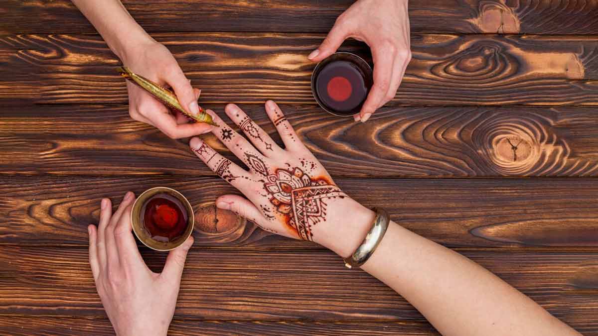 Artist applying henna mehndi tattoo on female hand Stock Photo | Adobe Stock